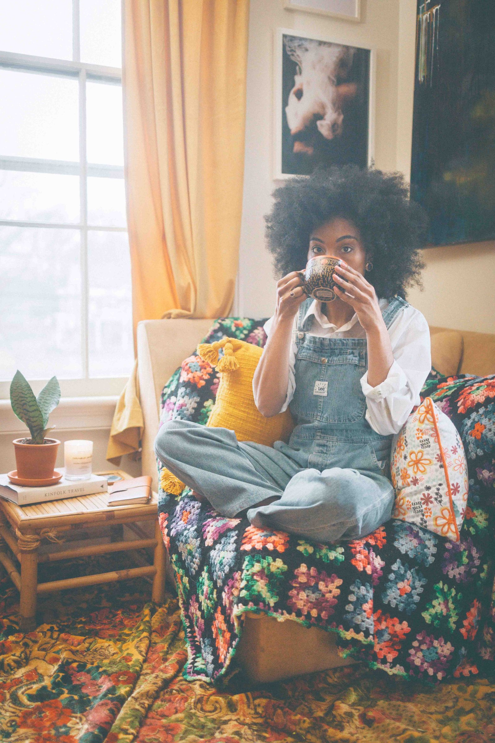 woman enjoying coffee in cozy bohemian lifestyle living room with vintage decor