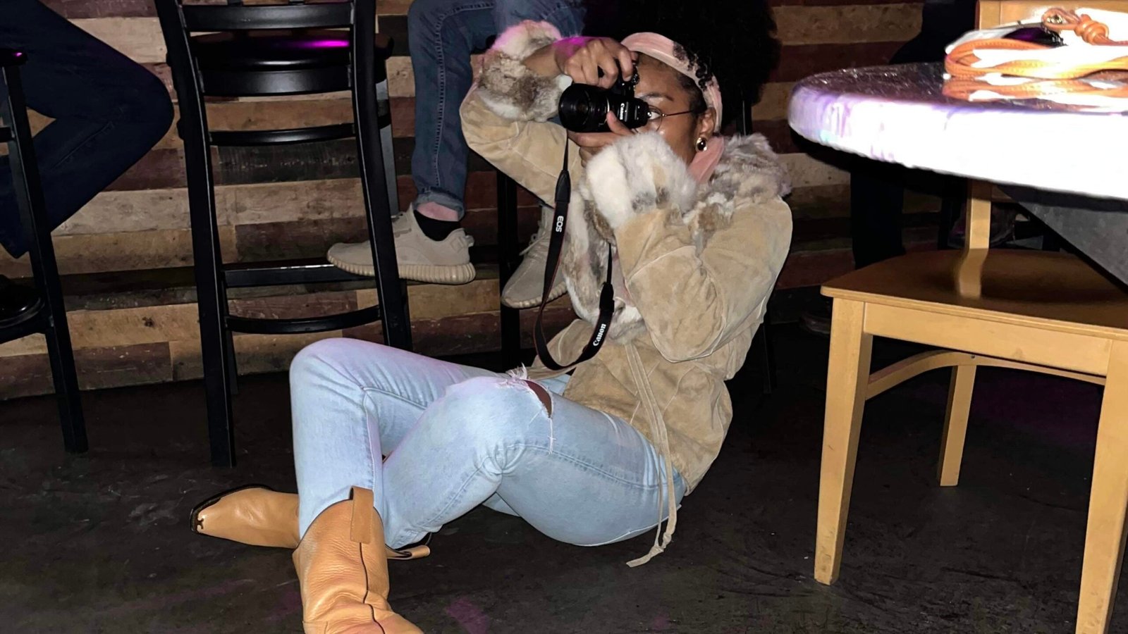 bohemian photographer taking pictures in a vintage coat and cowboy boots.  