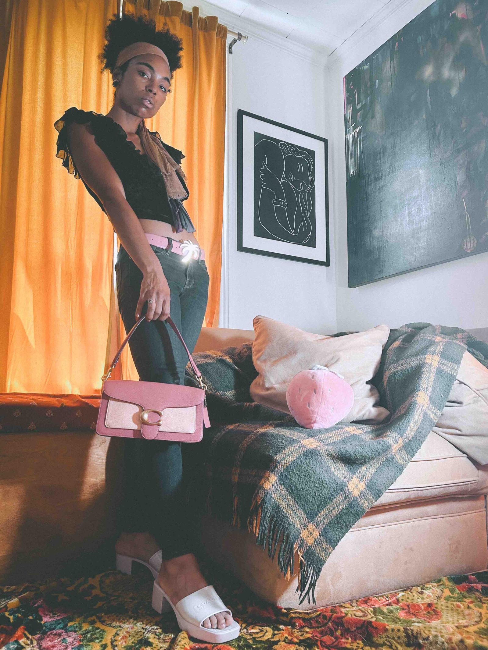 Full-body shot of a Y2K denim outfit featuring a pink Palm Angels belt and Coach shoulder bag, styled with Coach jelly slides.