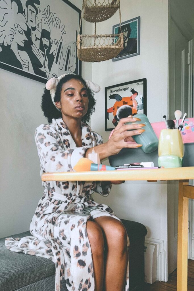 Bohemian beauty ritual before my New York art show debut — applying makeup in a leopard robe with a headband and glowy skin.