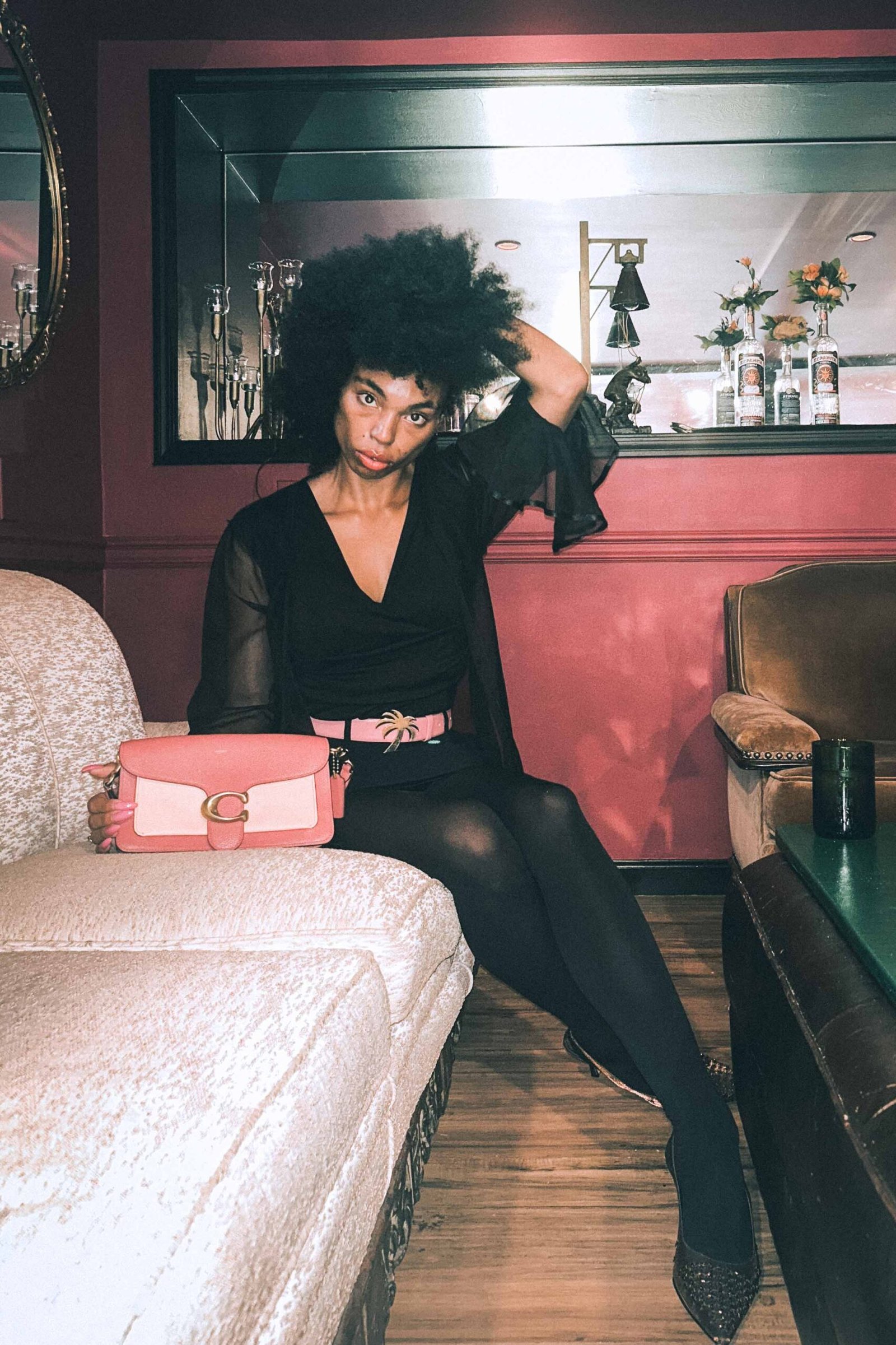 Inside my closet, feminine boho luxe all black evening outfit with pink palm angels belt and pink Coach bag.
