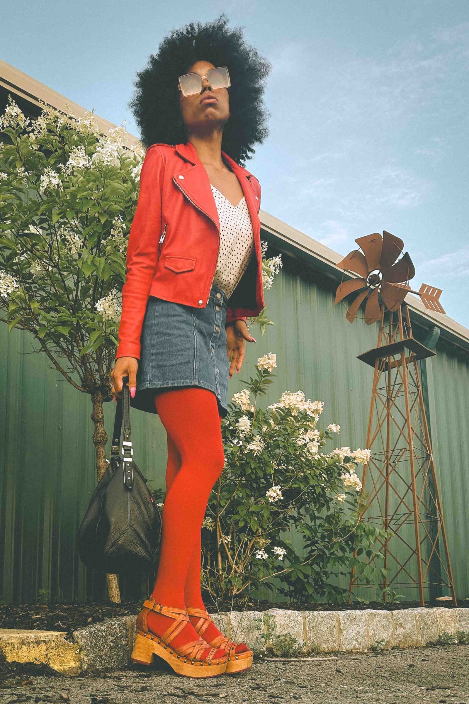 Inside My Closet look with a fire-engine red leather moto jacket, denim mini skirt, and red tights, styled as a bold statement piece for everyday wear.