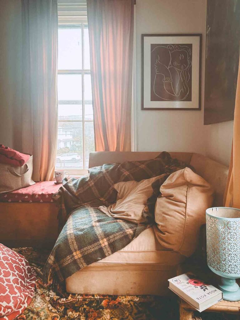 bohemian chic living room curated with thrifted finds. Afternoon sunlight spills into the tranquil space.