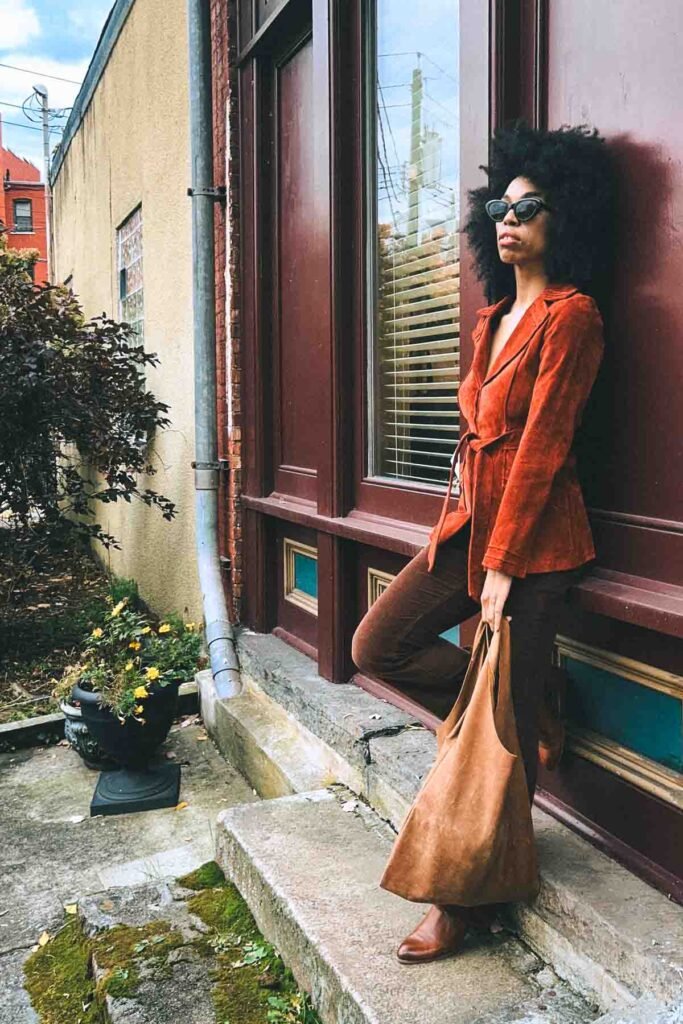 Fall boho outfit with burnt orange suede jacket, brown corduroy pants, and oversized tote bag styled by a bohemian fashion blogger in New York.
