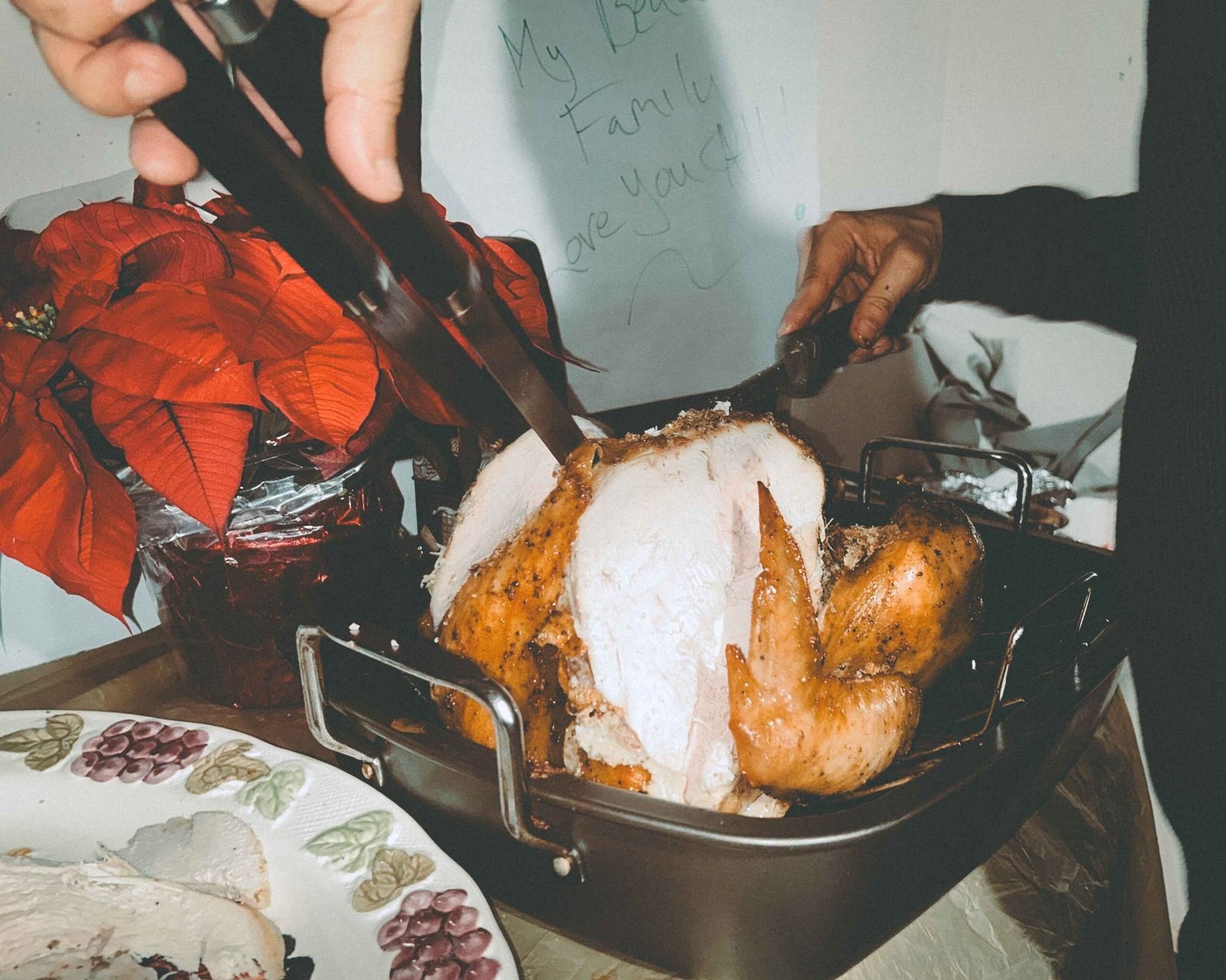A Thanksgiving turkey being carved on a crowded family table, highlighting the contrast between family celebrations and the quiet ache of being single during the holidays.