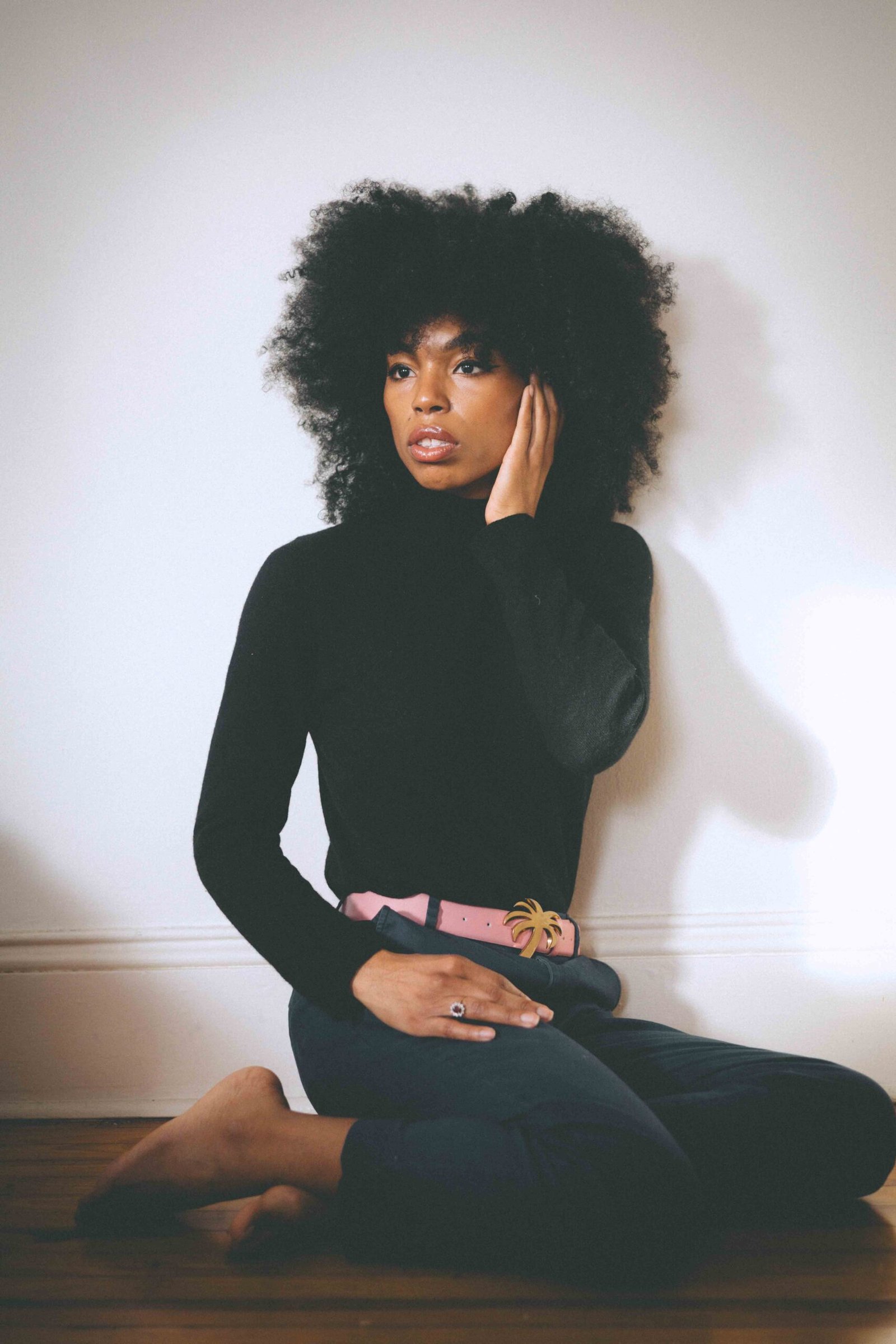 Editorial-style portrait showcasing a black cashmere sweater with relaxed yet elegant winter styling