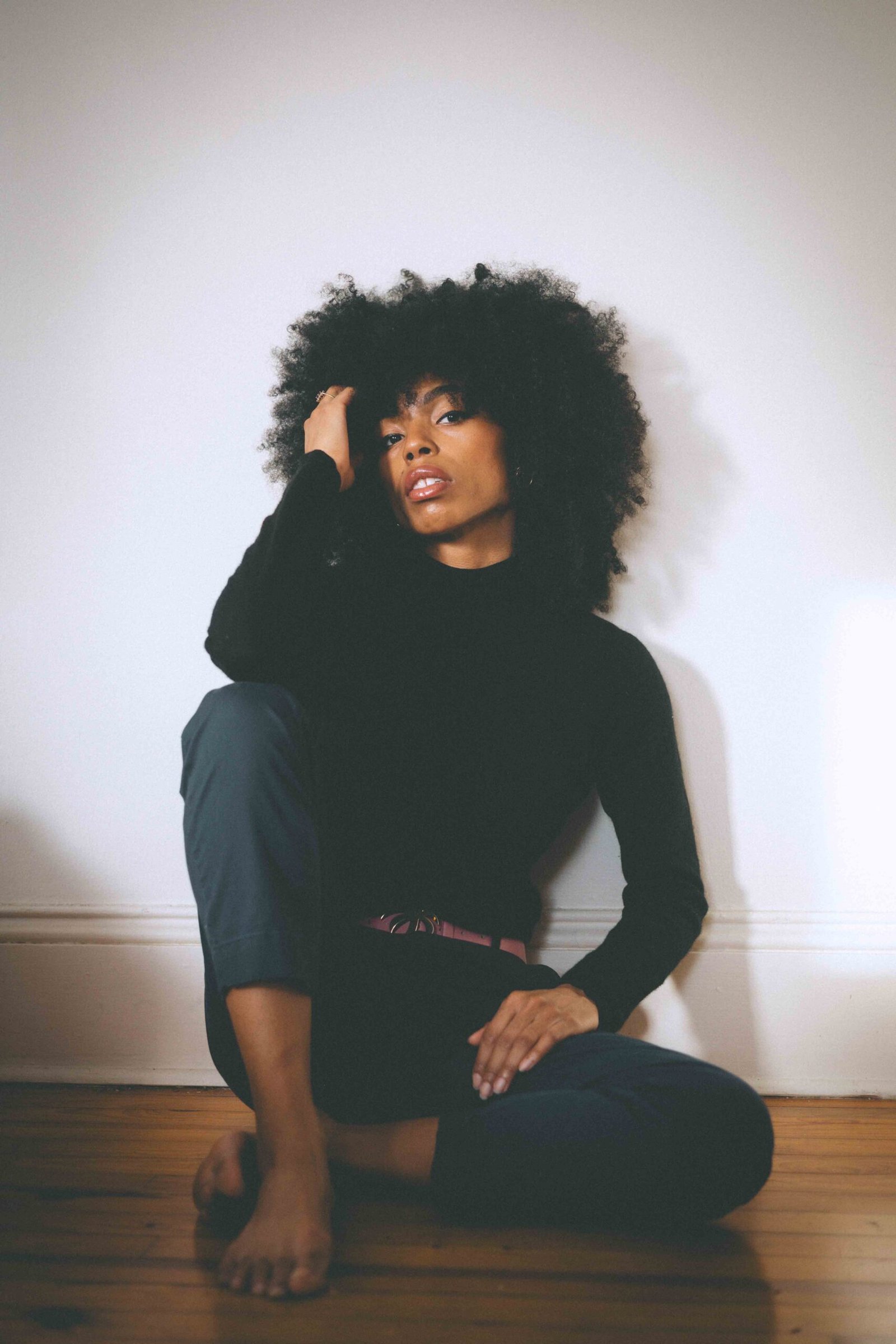 Black cashmere sweater worn with tailored trousers, styled as a classic winter wardrobe essential

