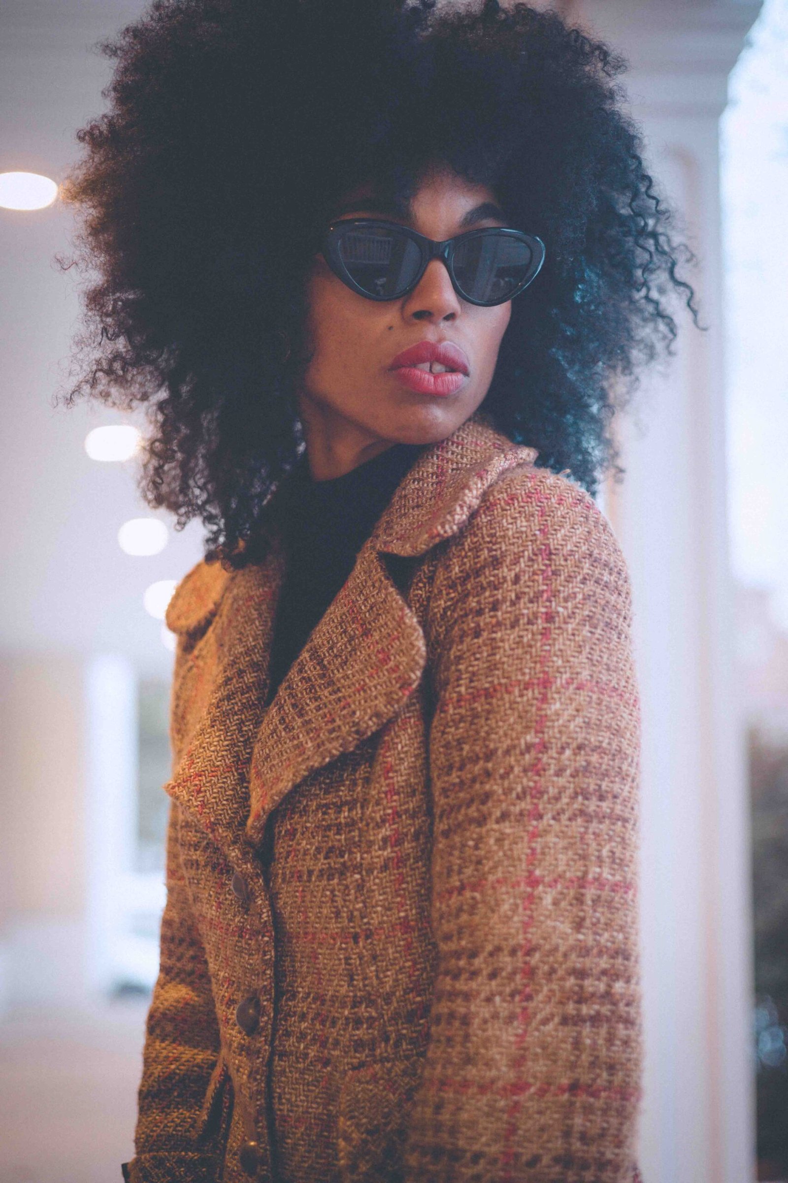 Close-up of a wool tweed coat showing rich texture, classic tailoring, and vintage-inspired winter design