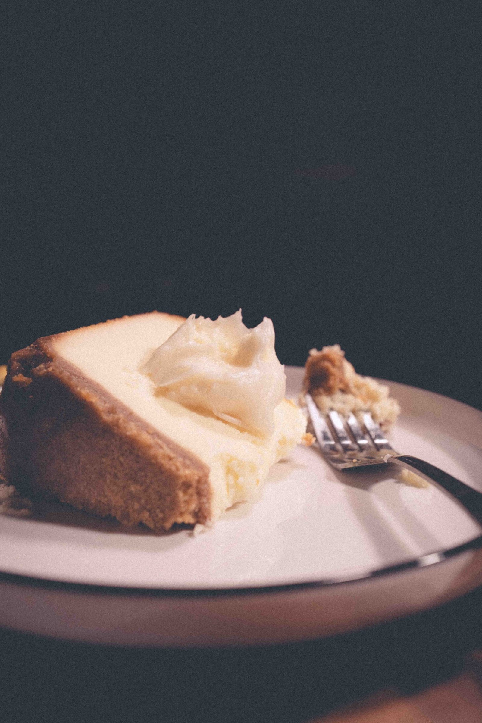 Close-up of cheesecake on a plate, a comforting dessert enjoyed as a nighttime ritual.