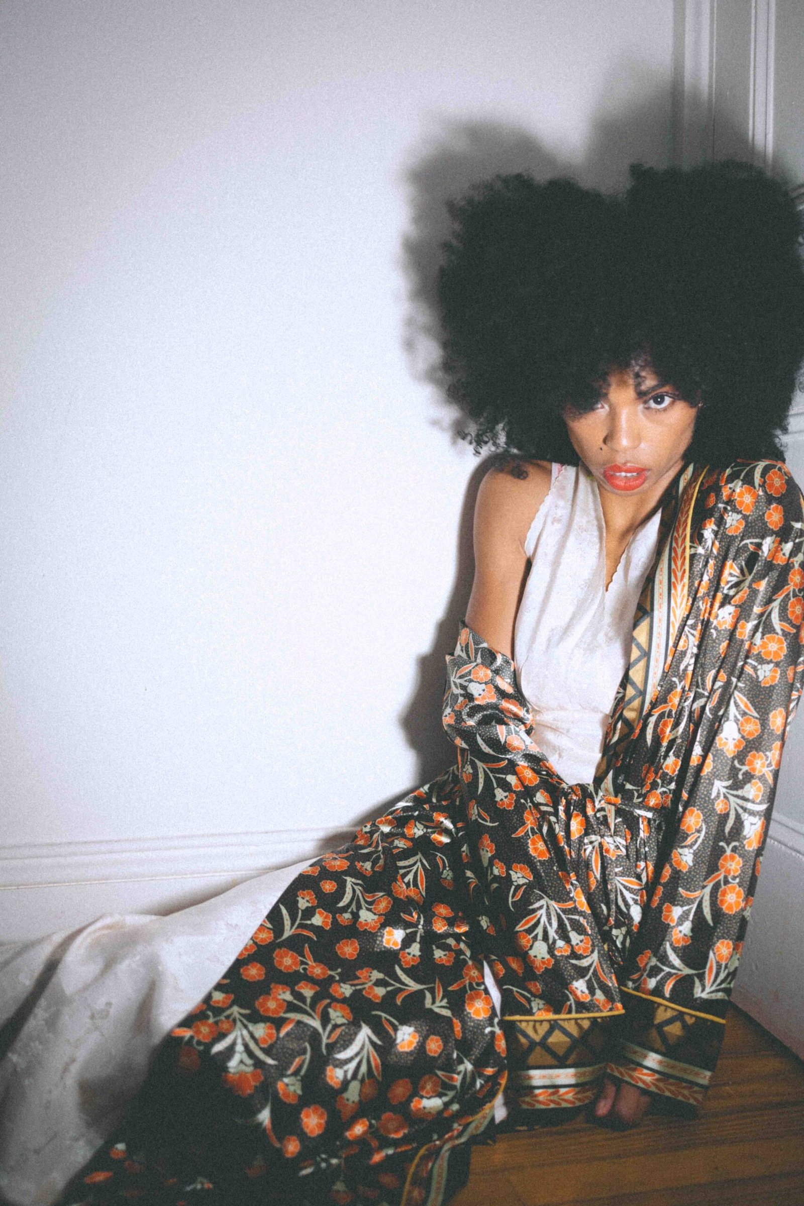 Art girl winter portrait featuring a floral robe layered over a slip dress, photographed indoors with soft light and a cinematic, lived-in feel.