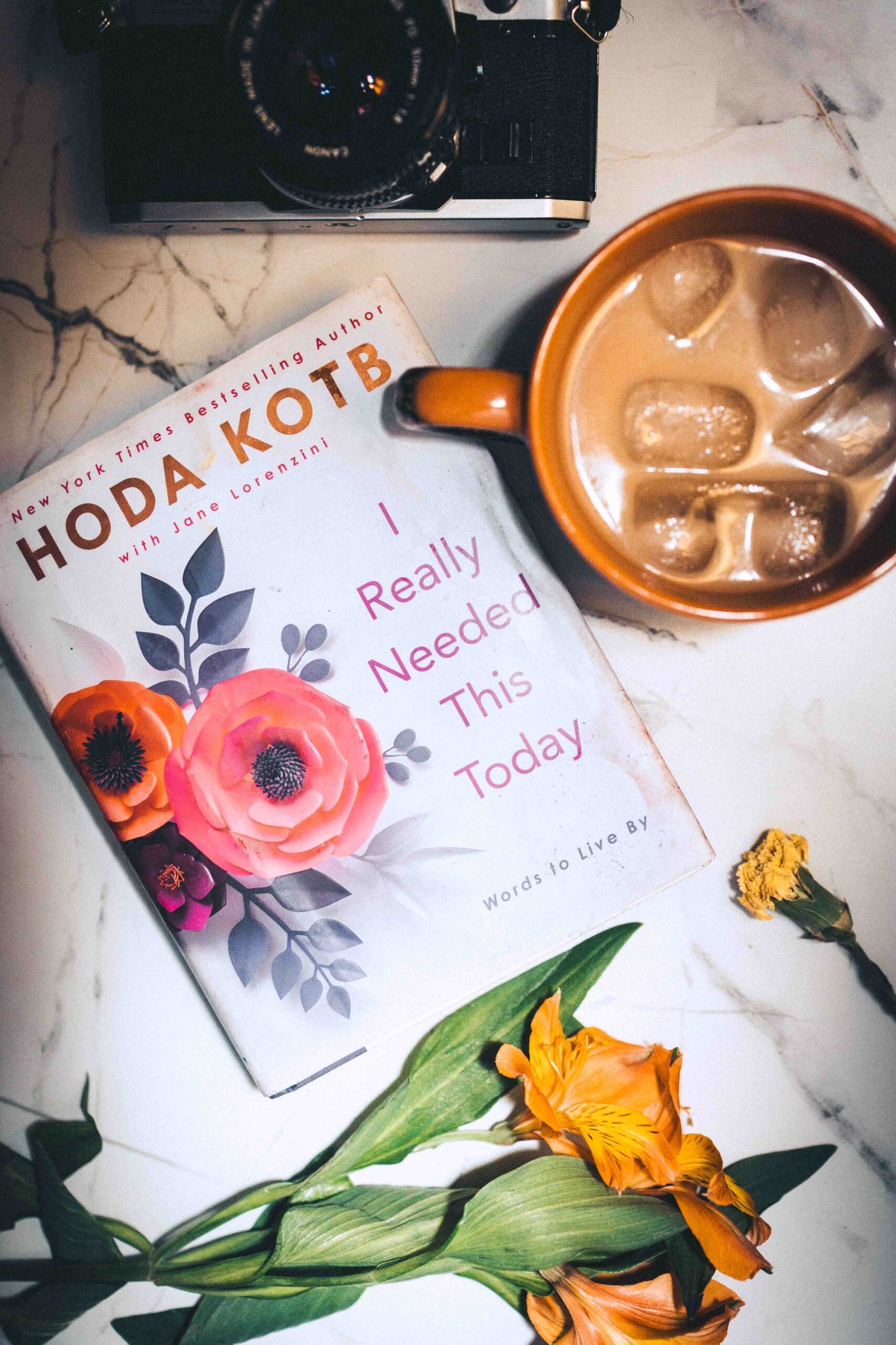 Creative morning flat lay with coffee, book, and camera, reflecting painting as therapy and a reflective artistic lifestyle.