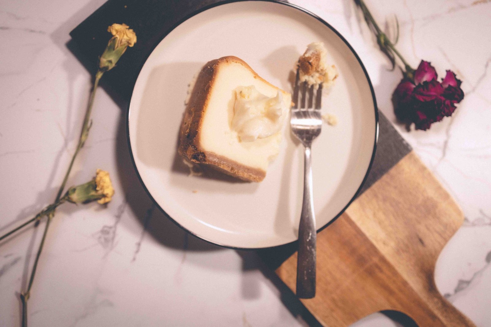 Slice of cheesecake on a plate with a fork, styled as a small dessert ritual and everyday little luxury.