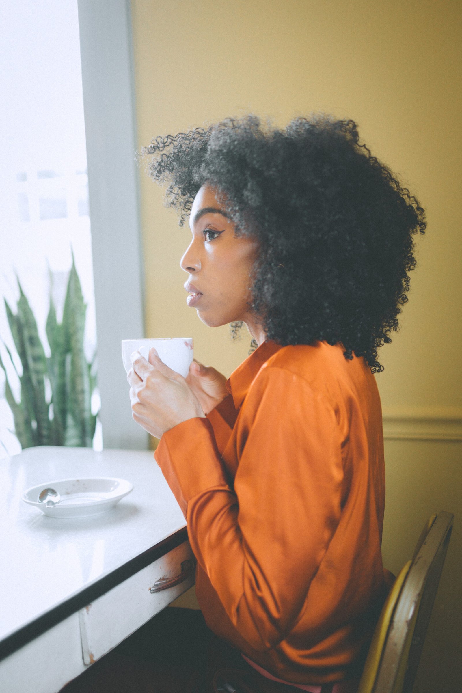 Side profile of a woman enjoying a quiet hot chocolate moment while alone on Valentine’s Day.