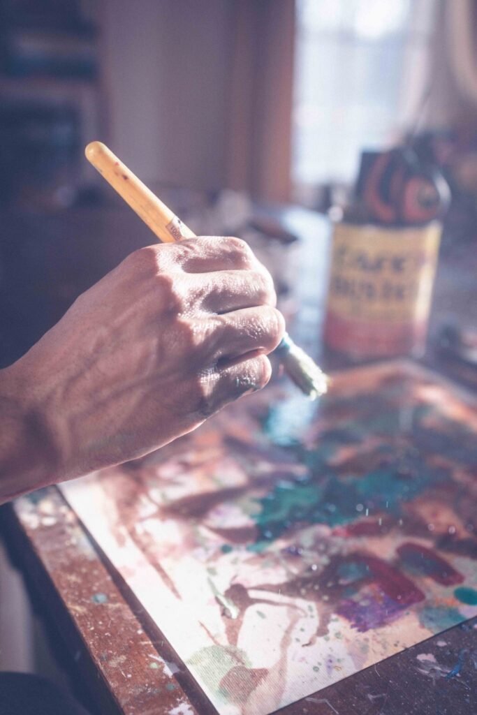 Close-up of paintbrush and artwork capturing the raw creative process of an artist