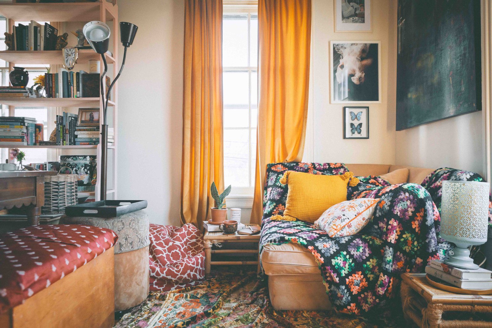 Cozy bohemian apartment living room with crochet blanket, thrifted furniture, and warm natural light