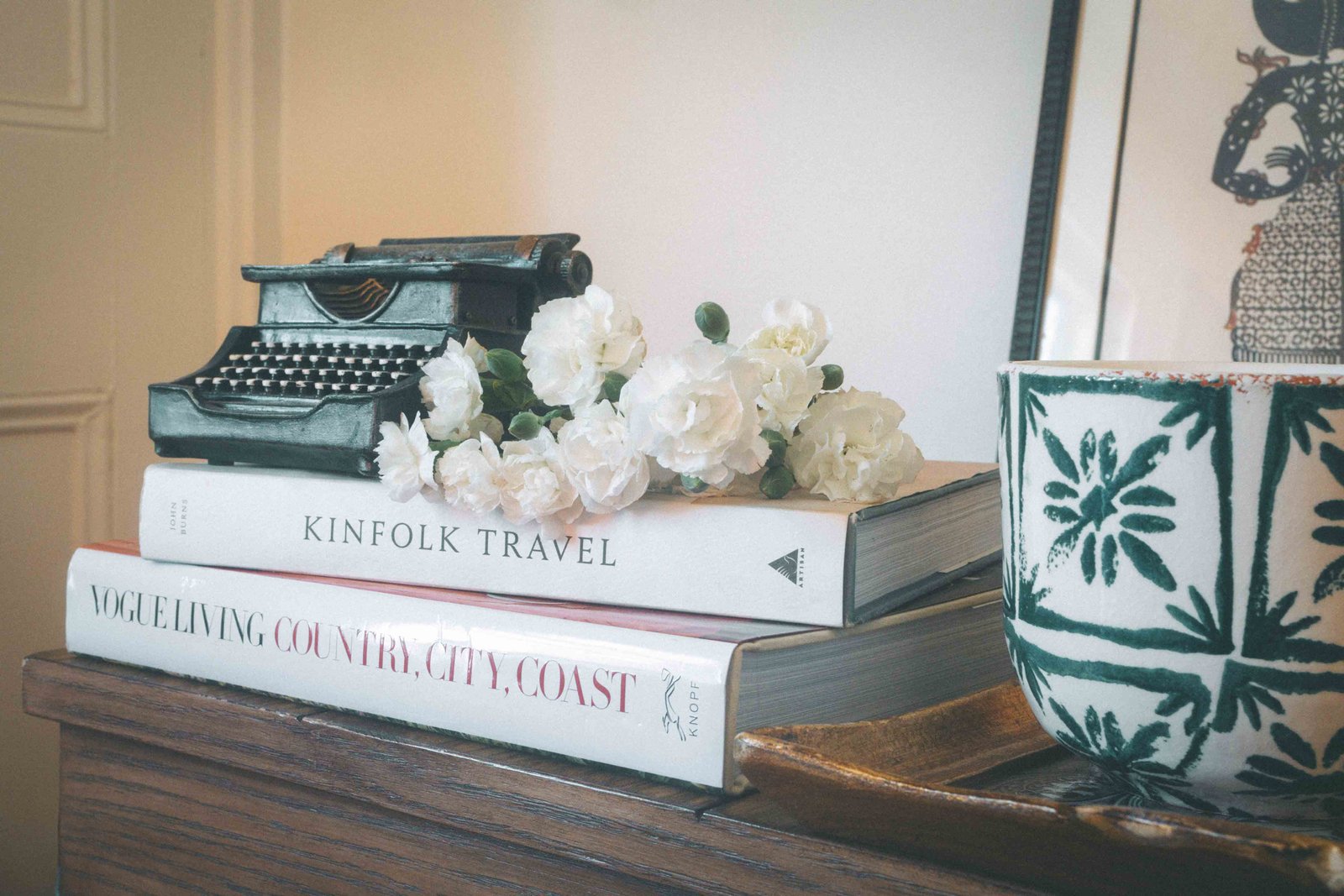 Vintage typewriter styled on books with flowers in a bohemian apartment decor vignette