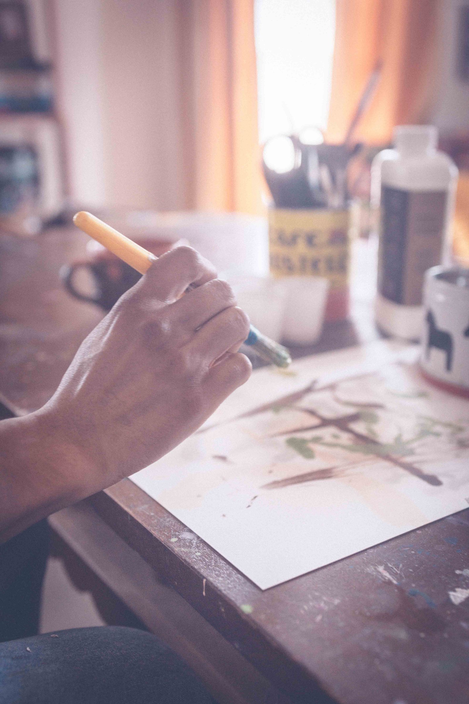 Close-up of hand painting on paper during creative block recovery and artistic practice