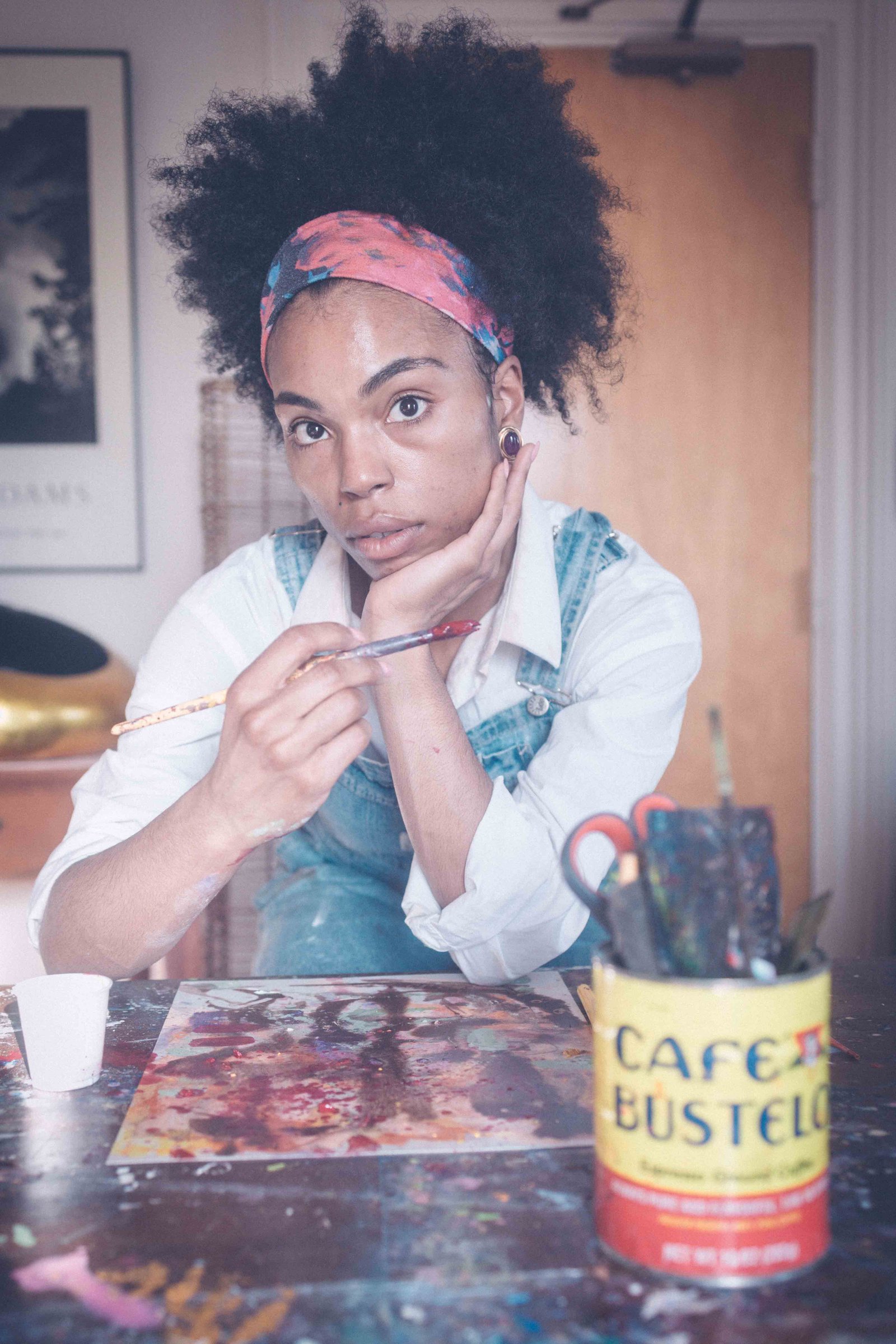 Artist holding paintbrush while embracing imperfect creative process and practice