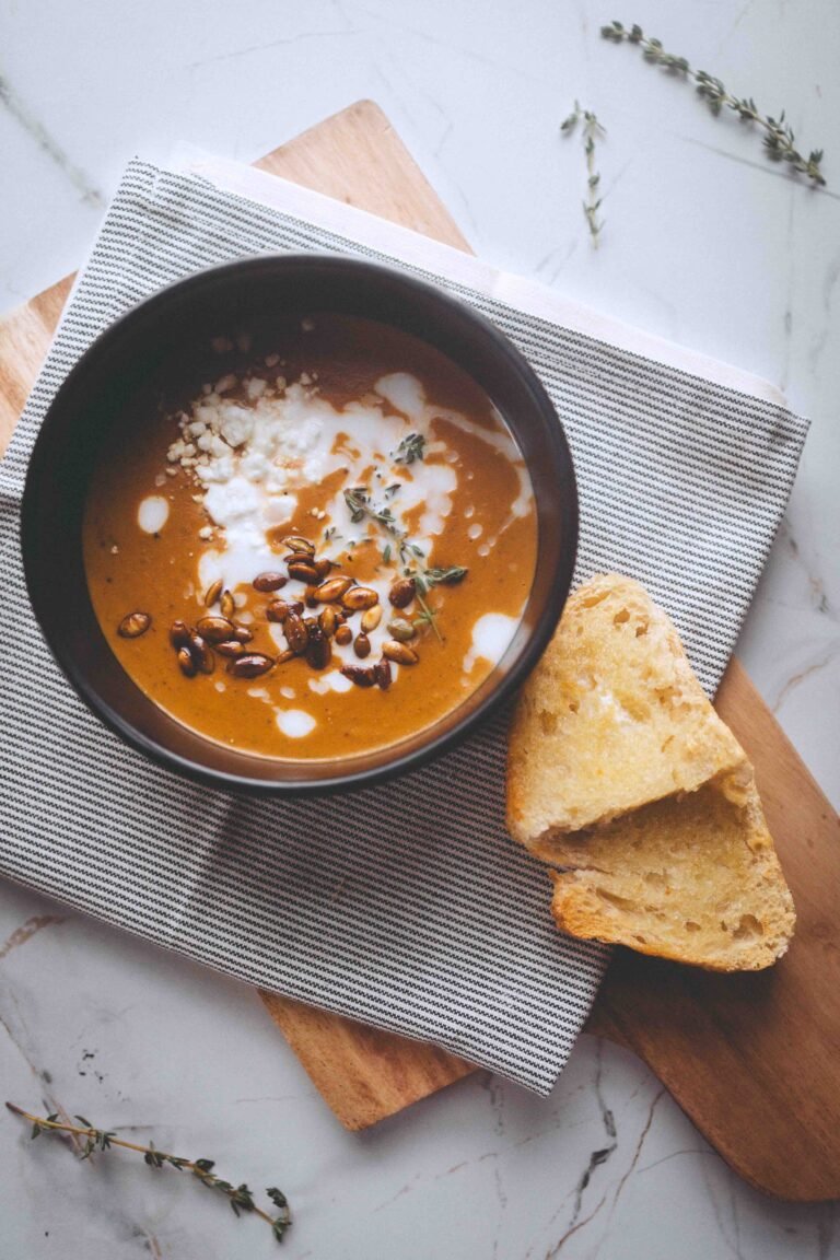 creamy butternut squash soup topped with pumpkin seeds and goat cheese with fresh bread for a slow Sunday meal