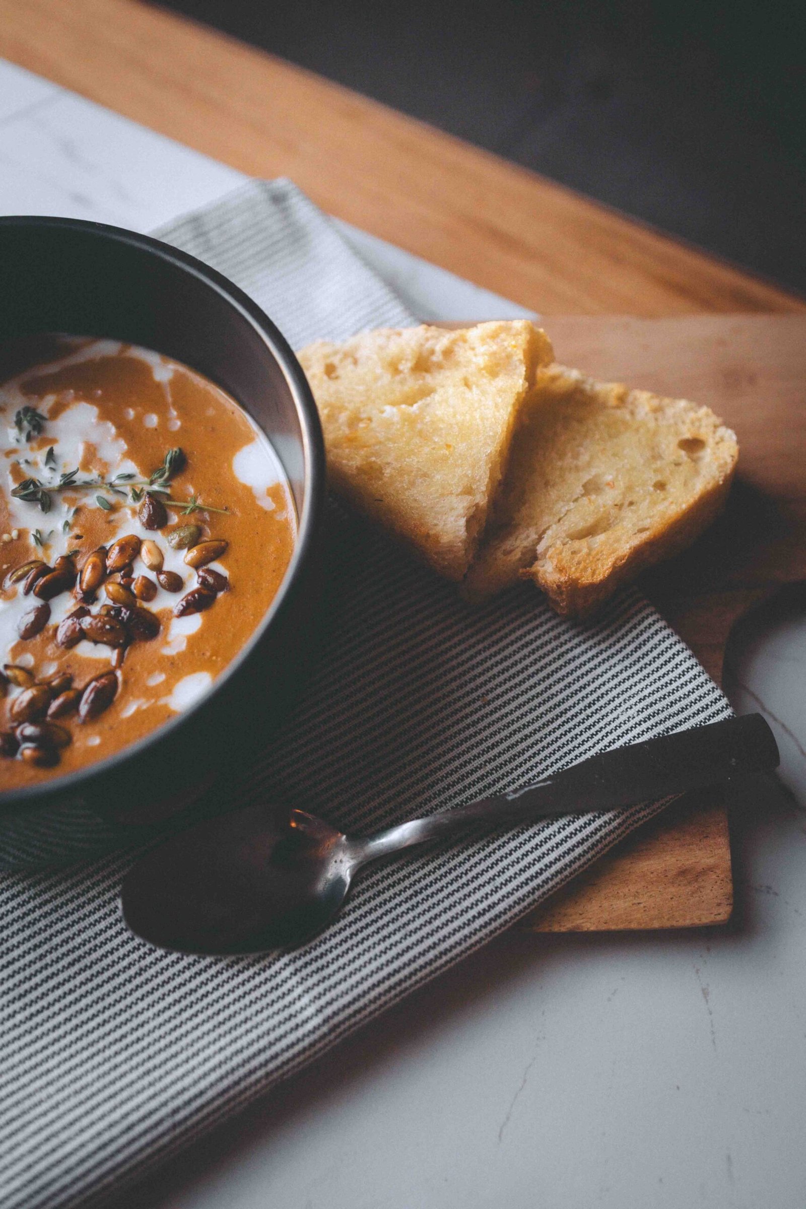 creamy homemade butternut squash soup with goat cheese thyme and toasted pumpkin seeds