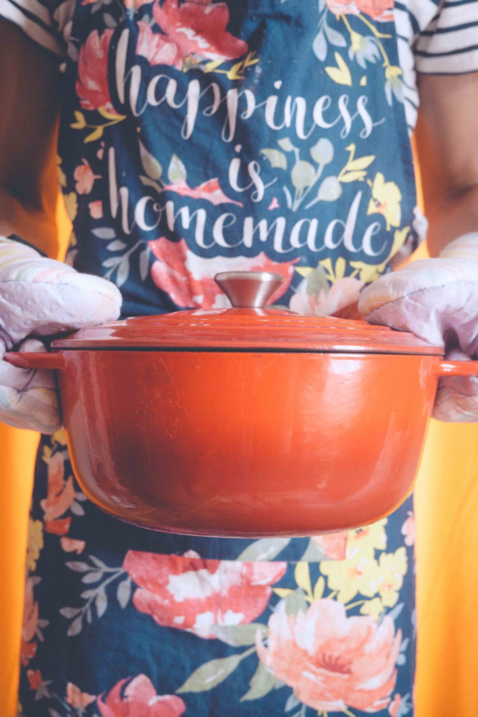 holding a red dutch oven with homemade butternut squash soup during slow Sunday rituals at home