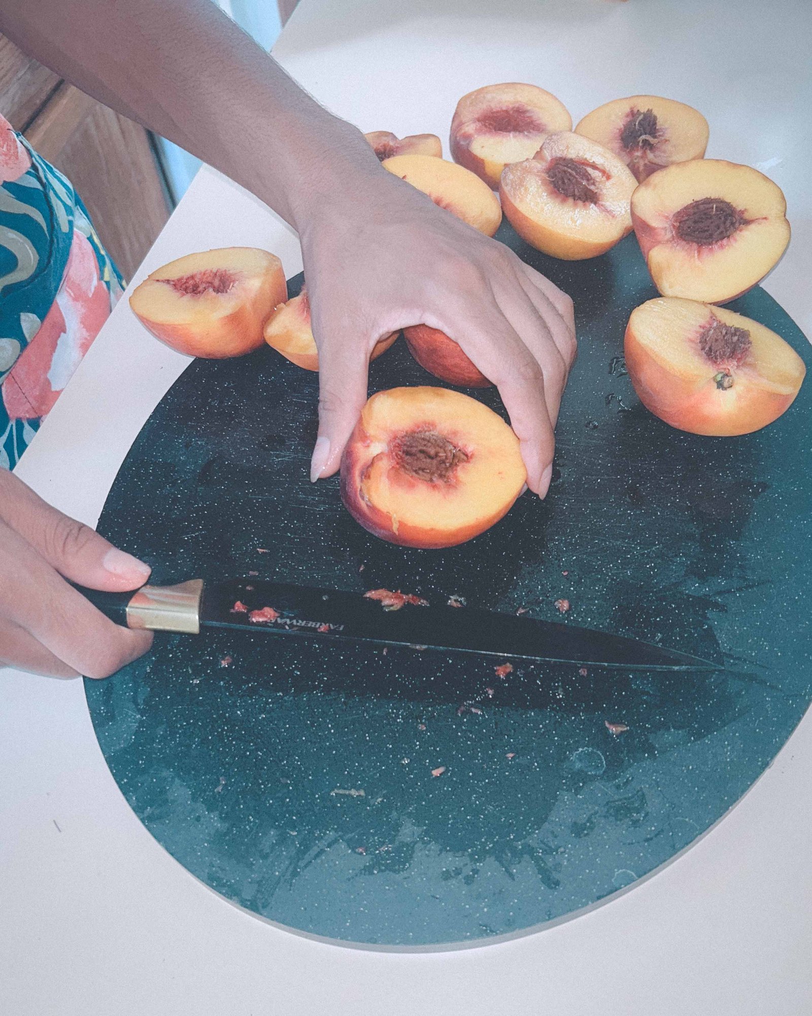 Fresh peaches being cut and prepared for homemade peach cobbler.