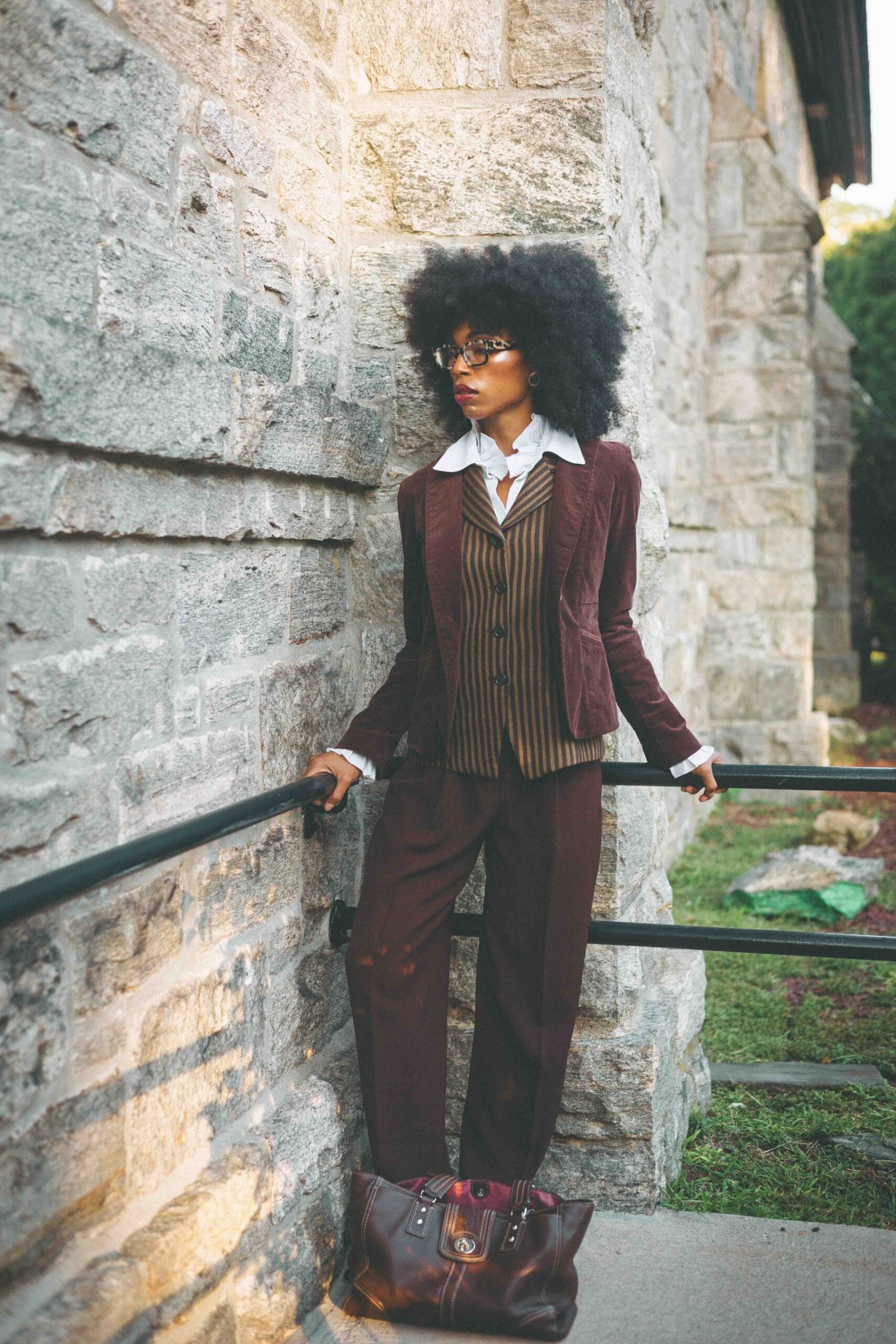 Woman wearing layered vintage brown tailoring with a corduroy blazer and striped wool waistcoat