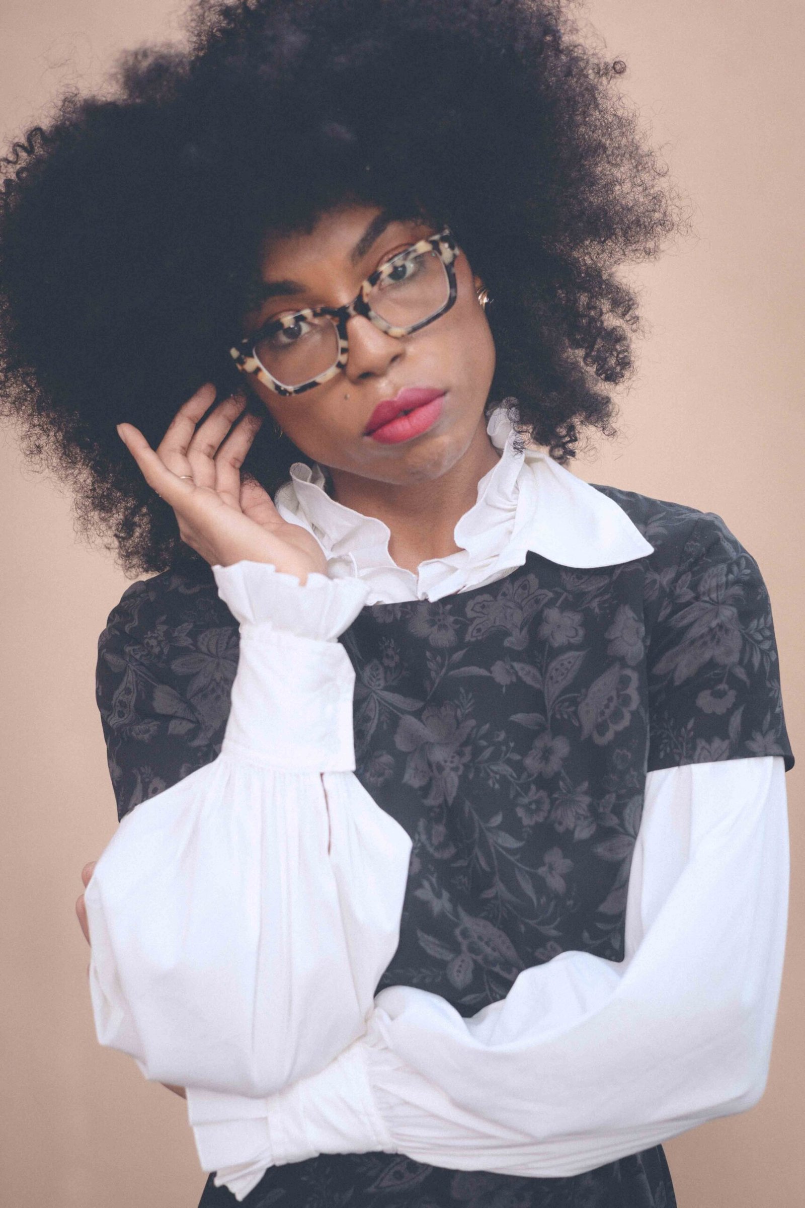 Close portrait showing a white poet blouse layered beneath a vintage dark floral dress