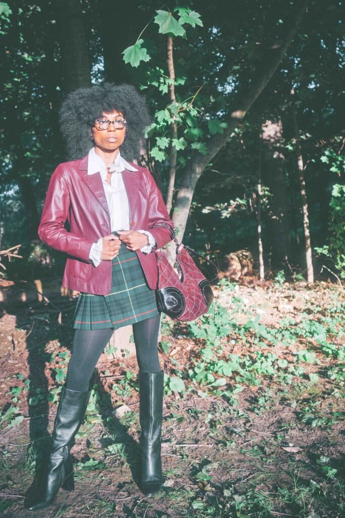 Full-length view of a Scottish wool plaid skirt styled with a vintage leather blazer and tall black boots