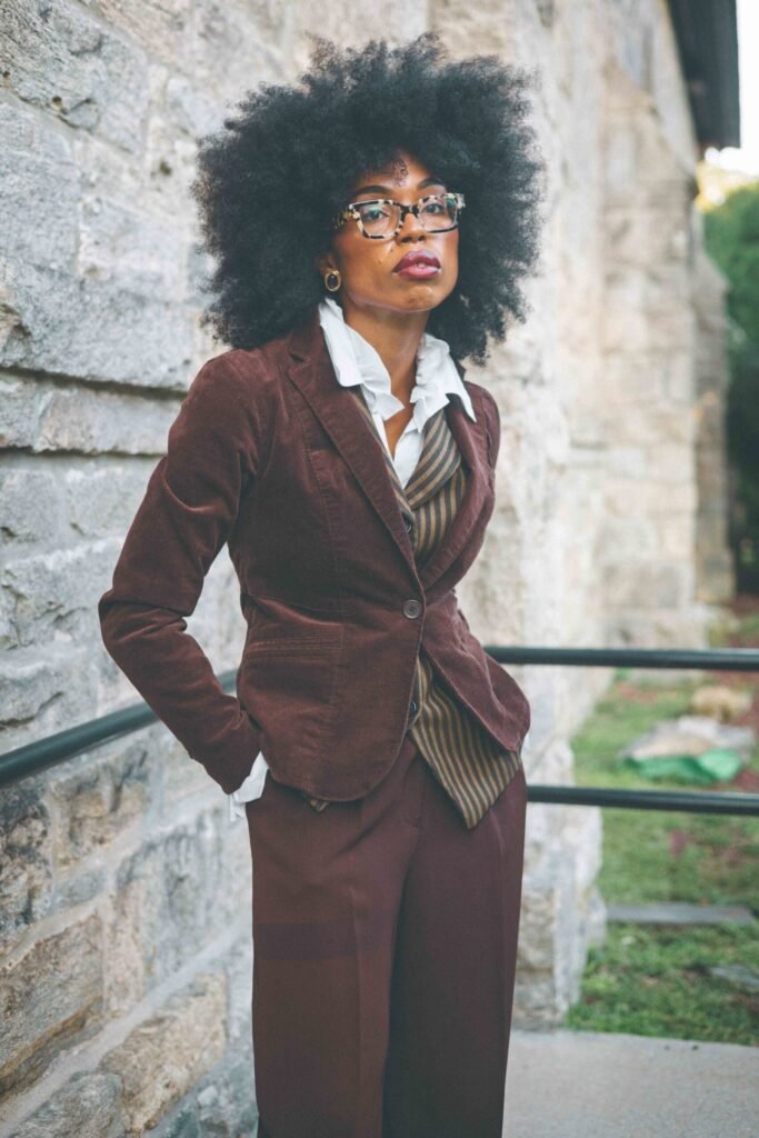Woman wearing a vintage brown corduroy blazer over a striped wool waistcoat and white poet blouse.